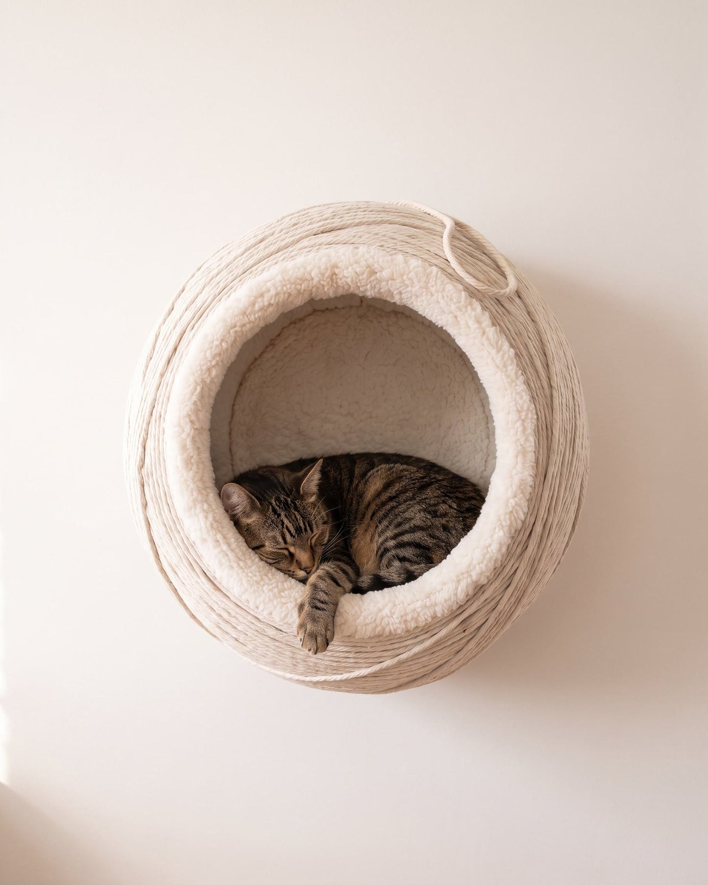 Snug Ledge String Pod, front view, cord-wrapped sphere with sherpa lining
