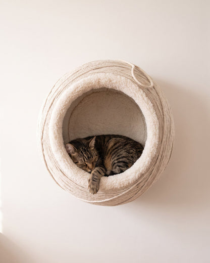 Snug Ledge String Pod, front view, cord-wrapped sphere with sherpa lining